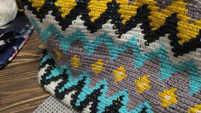 Bag crocheted from multi-colored threads. Yellow with gray, black and other colors in jacquard knitted fabric. Handmade