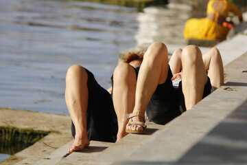 tourists taking sunbath near ghaat of a lake