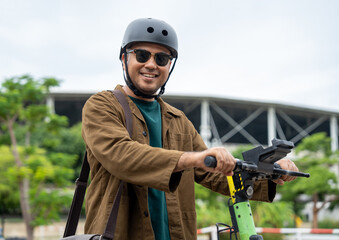 Young Asian man ride scooter EV eco friendly transport. Sustainable save energy lifestyle. Commute and carbon neutral transportation. Asian tourist man put on helmet ride the scooter EV