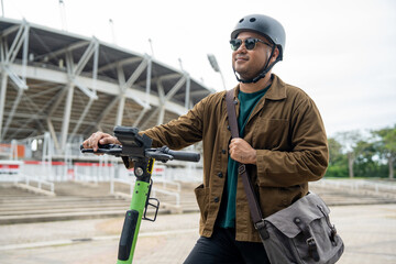Young Asian man ride scooter EV eco friendly transport. Sustainable save energy lifestyle. Commute and carbon neutral transportation. Asian tourist man put on helmet ride the scooter EV