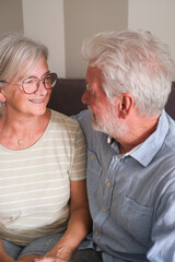 Senior couple in their 70s sharing loving and tender moments at home. A heartwarming scene of...