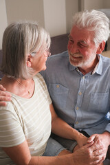 Senior couple in their 70s sharing loving and tender moments at home. A heartwarming scene of...