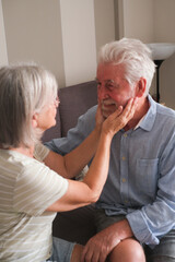 Senior couple in their 70s sharing loving and tender moments at home. A heartwarming scene of lasting love, emotional connection, companionship, and the joy of growing old together