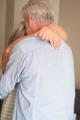 Senior couple in their 70s sharing loving and tender moments at home. A heartwarming scene of...