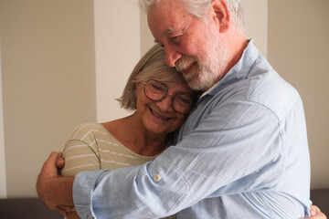 Senior couple in their 70s sharing loving and tender moments at home. A heartwarming scene of...