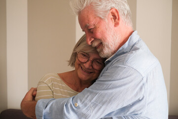 Senior couple in their 70s sharing loving and tender moments at home. A heartwarming scene of...