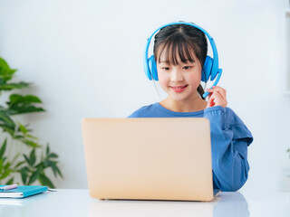 Girl studying on a laptop with headphones on