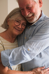 Senior couple in their 70s sharing loving and tender moments at home. A heartwarming scene of...
