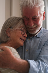Senior couple in their 70s sharing loving and tender moments at home. A heartwarming scene of...