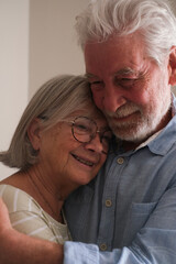 Senior couple in their 70s sharing loving and tender moments at home. A heartwarming scene of...