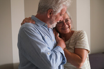 Senior couple in their 70s sharing loving and tender moments at home. A heartwarming scene of...