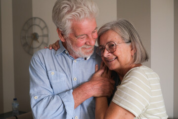 Senior couple in their 70s sharing loving and tender moments at home. A heartwarming scene of...