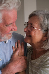 Senior couple in their 70s sharing loving and tender moments at home. A heartwarming scene of...