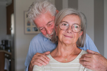 Senior couple in their 70s sharing loving and tender moments at home. A heartwarming scene of...
