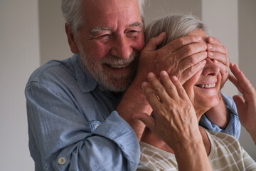 Senior couple in their 70s sharing loving and tender moments at home. A heartwarming scene of...