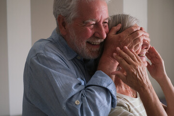 Senior couple in their 70s sharing loving and tender moments at home. A heartwarming scene of...