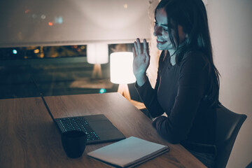 Young woman alone at home working late at night on her laptop. Freelancing, studying, chatting...