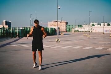 Athlete preparing for jump rope exercise on rooftop parking lot