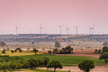 Generating renewable energy, a wind farm stands majestically over a picturesque countryside,...