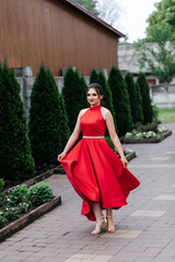 woman in red dress spinning on street in summer