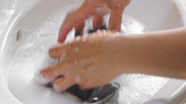 Washing clothes by hands in the basin.