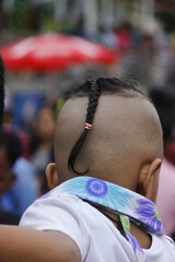 small kid with unique hairstyle at a fair
