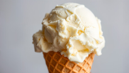シンプルな背景に置かれたワッフルコーンとバニラアイスクリームのスクープ