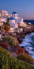 Picturesque coastal town with white buildings and blue domes at sunset