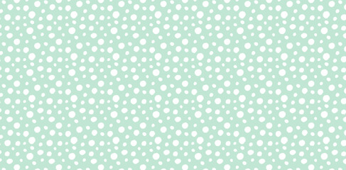 Seamless polka dot pattern with white dots on mint green background