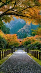 Autumnal path through a Japanese garden, framed by vibrant foliage and mountains