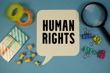 Human Rights text with magnifying glass on blue background