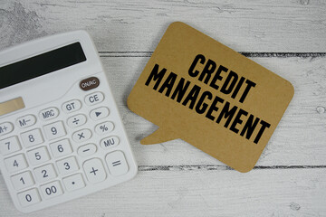Credit Management text with calculator on wooden background