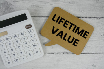 Lifetime Value text with calculator on wooden background