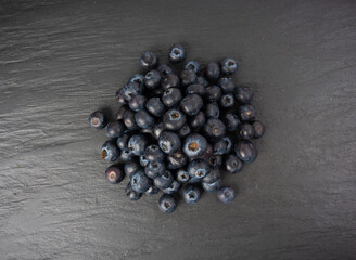 Blueberry on black plate. Fresh blue berry fruits, bilberry group on dark background