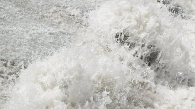 row of chute dentate blocks in concrete water spillway channel slope slowing down splashing flow of water running down.