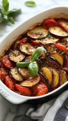 Delicious homemade ratatouille in white ceramic dish with fresh basil and herbs for gourmet meal preparation