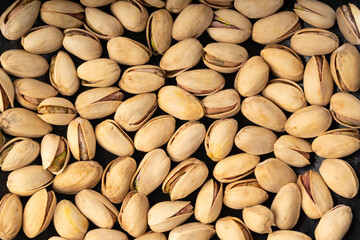 Fried salt pistachio nuts texture background. Baked pistachios pattern, roasted green pistache