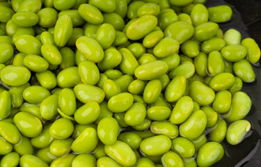 Edamame beans bowl textured background. Green soy bean pattern, many cooked young soybeans