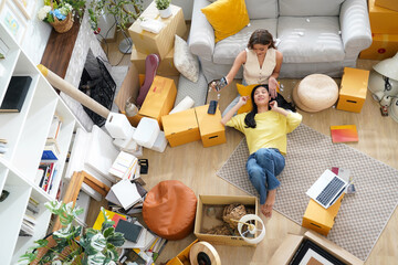 Young women and friend help moving home while packing boxes together and happy in new home.  Asia women investment real estate for living with family.  Investment and Family Concept