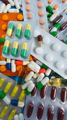 Various capsules and tablets scattered on a surface represent medications and pharmaceutical products for health concept