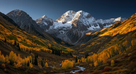 Majestic mountain range and vibrant fall foliage, bathed in warm sunlight. River flows through the valley