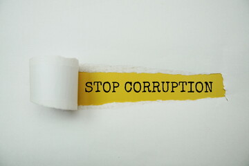 Stop Corruption message written on yellow paper with torn paper background