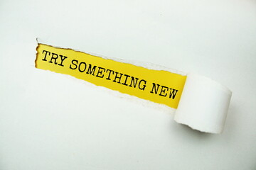 Try Something New message written on yellow paper with torn paper background