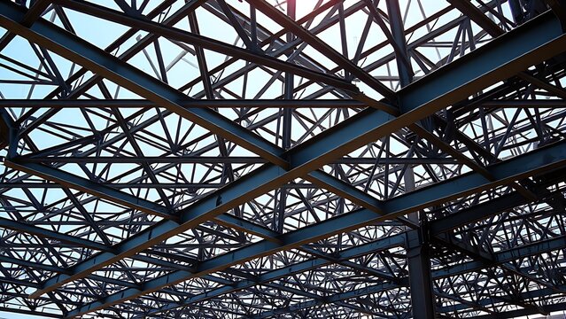 An industrial steel structure framework forming geometric patterns under daylight.