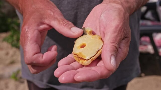 Caucasian Male Polishing Large Amber Rock With Sand Paper before Making Jewellery Necklace