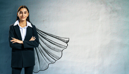 Confident businesswoman in suit with superhero cape drawing on wall symbolizing leadership,...