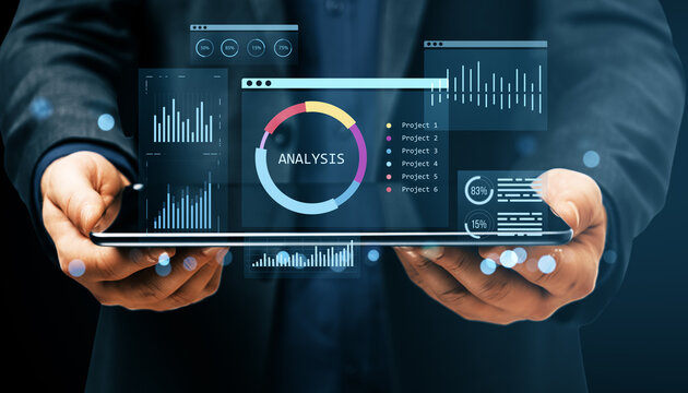 Businessman holding tablet with digital financial analysis dashboard, charts, and KPI infographics on futuristic virtual interface display.