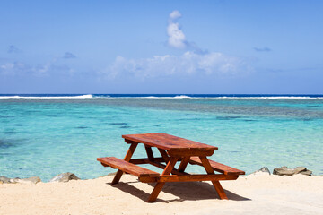 Crystal clear azure blue ocean water covering a shallow tropical reef under a deep blue sky.
