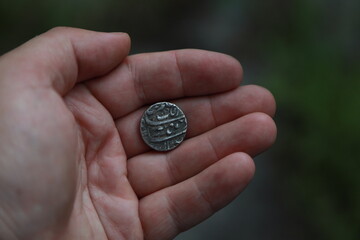 Medieval silver coin one rupee of India in hand