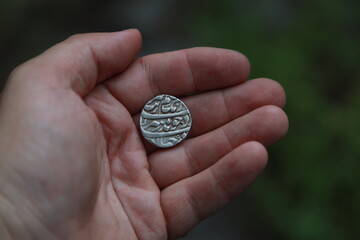 Medieval silver coin one rupee of India in hand